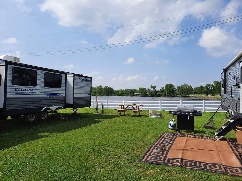 Grassy RV sites by the water at COOK'S LAKE RV RESORT & CAMPGROUND