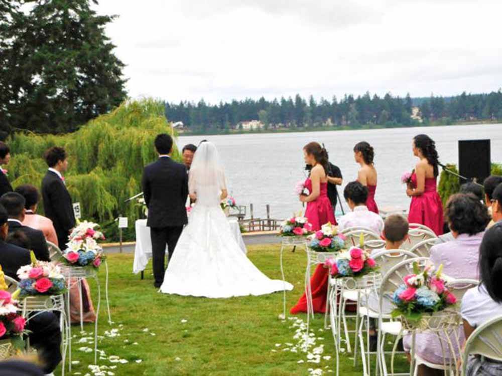 A couple having a wedding by the water at COOK'S LAKE RV RESORT & CAMPGROUND