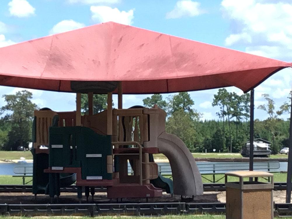 A play structure under a red pop-up at THOMPSON LAKE RV RESORT