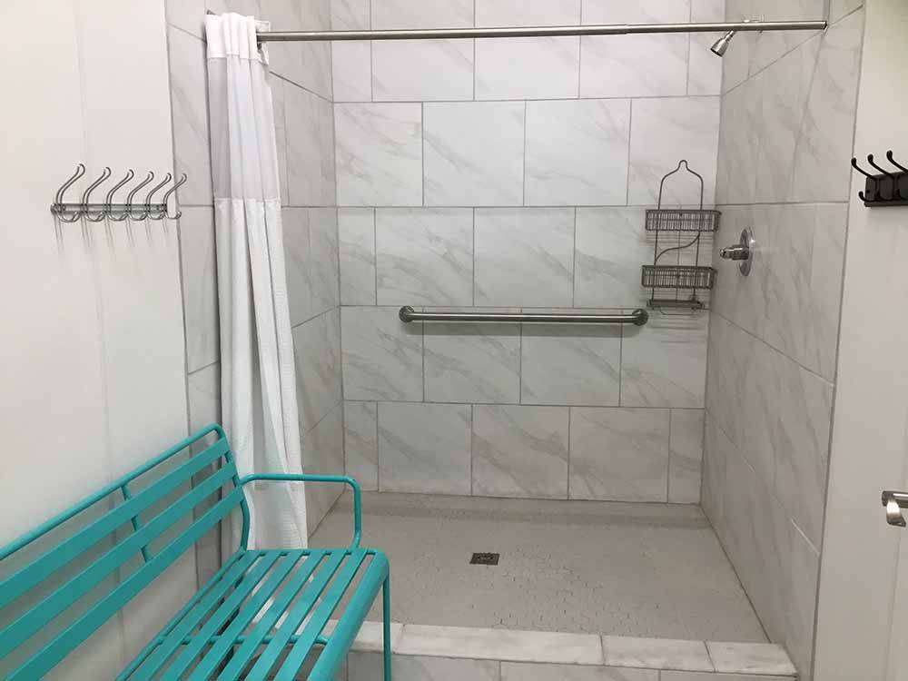 The shower stall with a bench next to it at SUNDANCE RV PARK