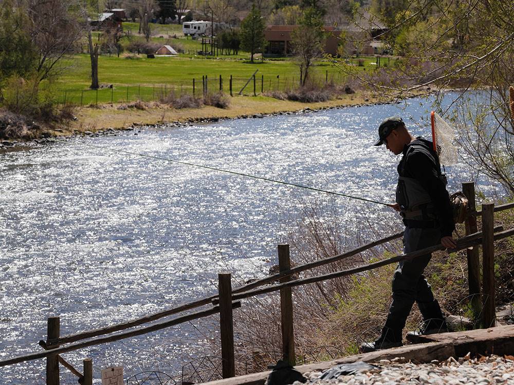 A man walking to the river to fish