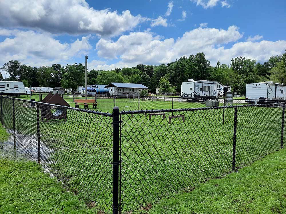 Fenced in dog park with play equipment at OUTPOST RV PARK & CAMPGROUND
