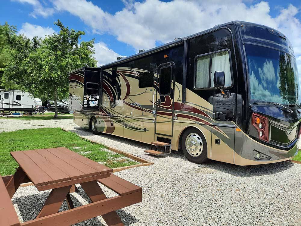 Motorhome in campsite with picnic table at OUTPOST RV PARK & CAMPGROUND