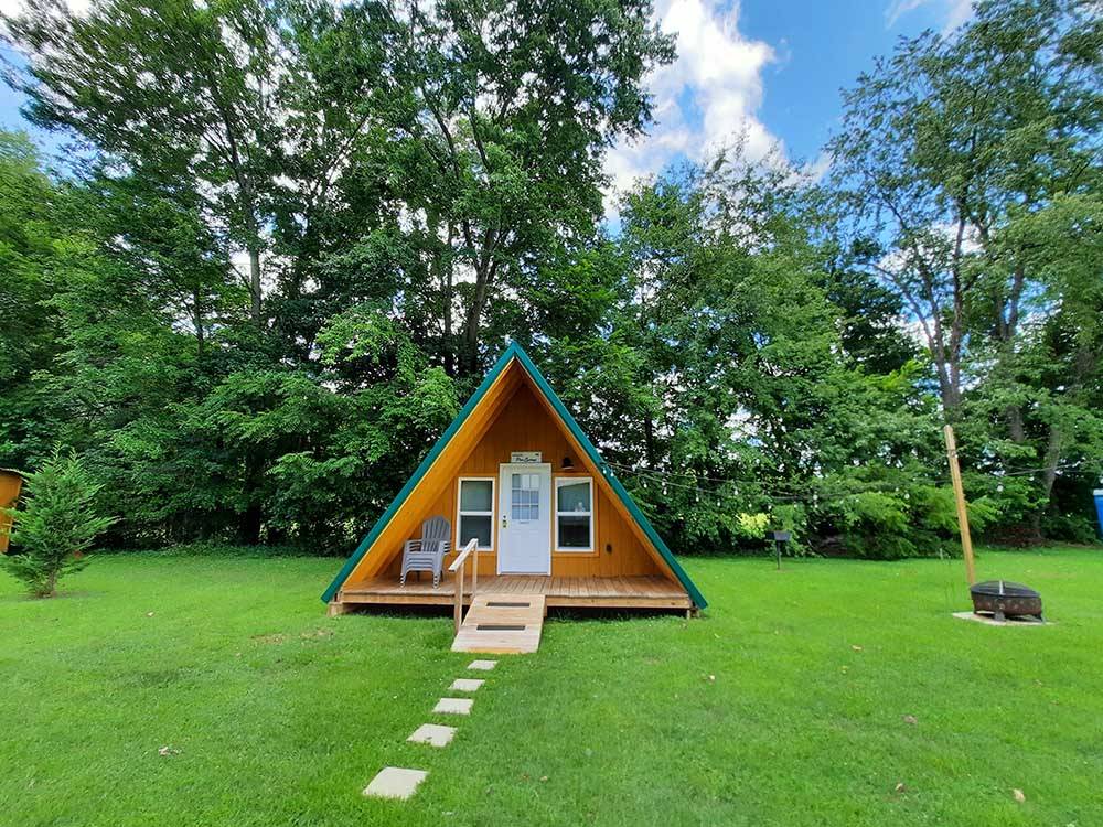 A-frame cabin with stone pavers leading to it at OUTPOST RV PARK & CAMPGROUND