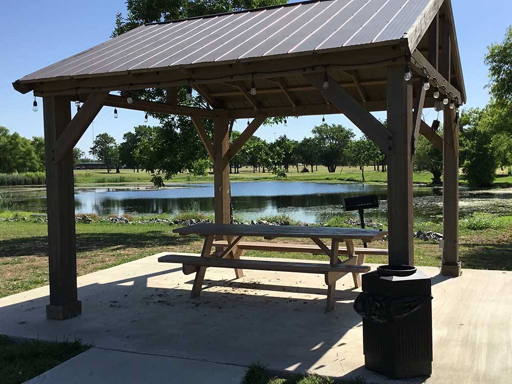 A gazebo with a picnic table by the water at STINSON RV PARK