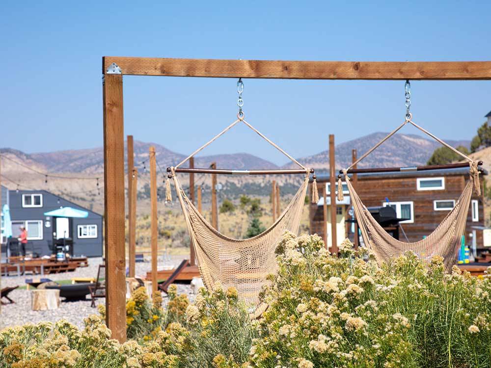 Hammock swings with tiny homes in distance at TRAIL & HITCH RV PARK AND TINY HOME HOTEL