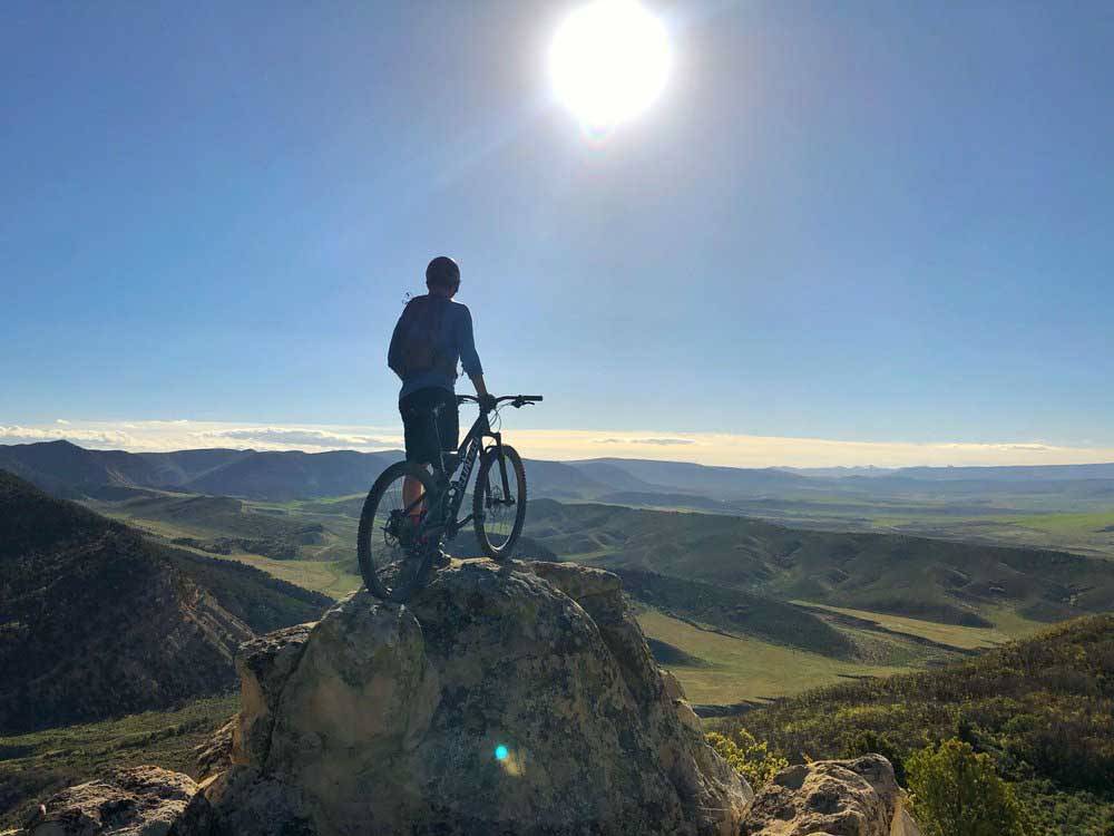 Mountain biker at top of hill near campground at TRAIL & HITCH RV PARK AND TINY HOME HOTEL