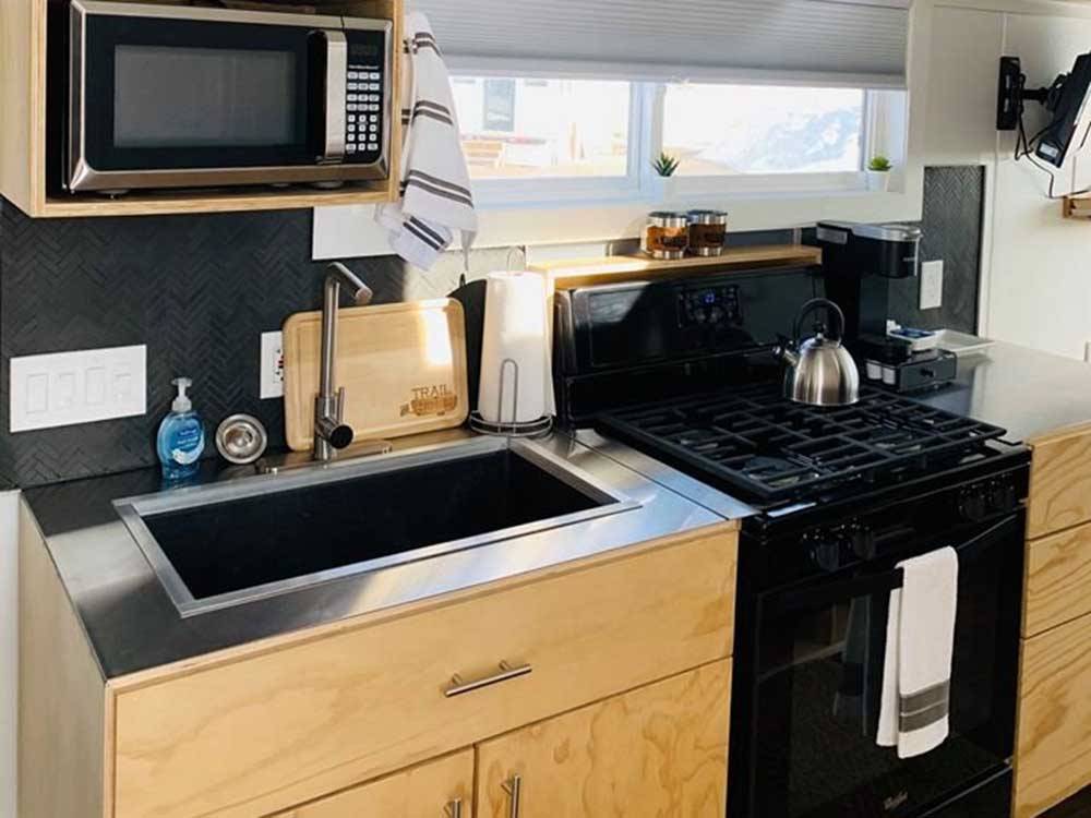 Kitchen area of Flat Top tiny home model at TRAIL & HITCH RV PARK AND TINY HOME HOTEL