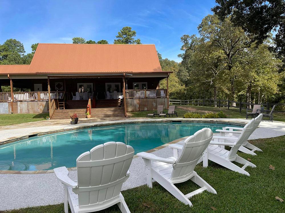 Chairs by the pool and lodge at FOREST LAKE RV PARK & EVENTS