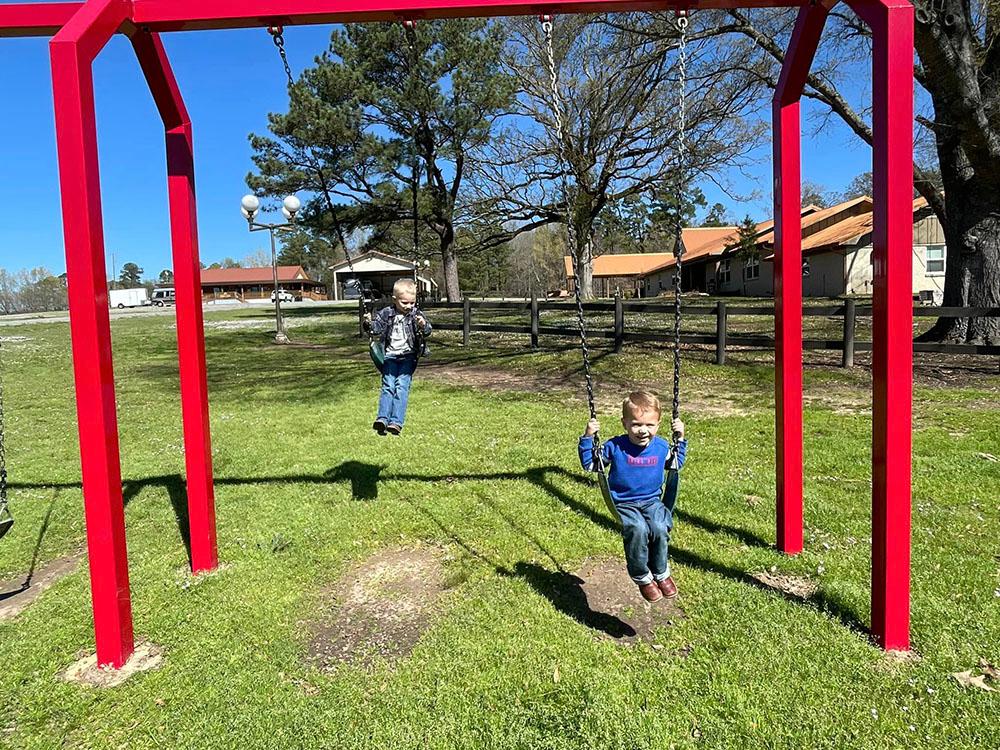 Kids playing on the swing set at FOREST LAKE RV PARK & EVENTS