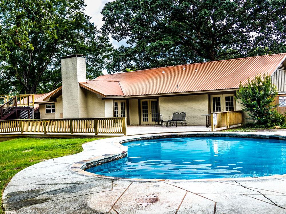 Pool area with view of the lodge at FOREST LAKE RV PARK & EVENTS