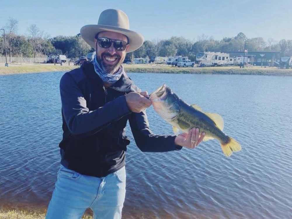 A man holding a fish he caught at ERIC & JAY'S RV RESORT