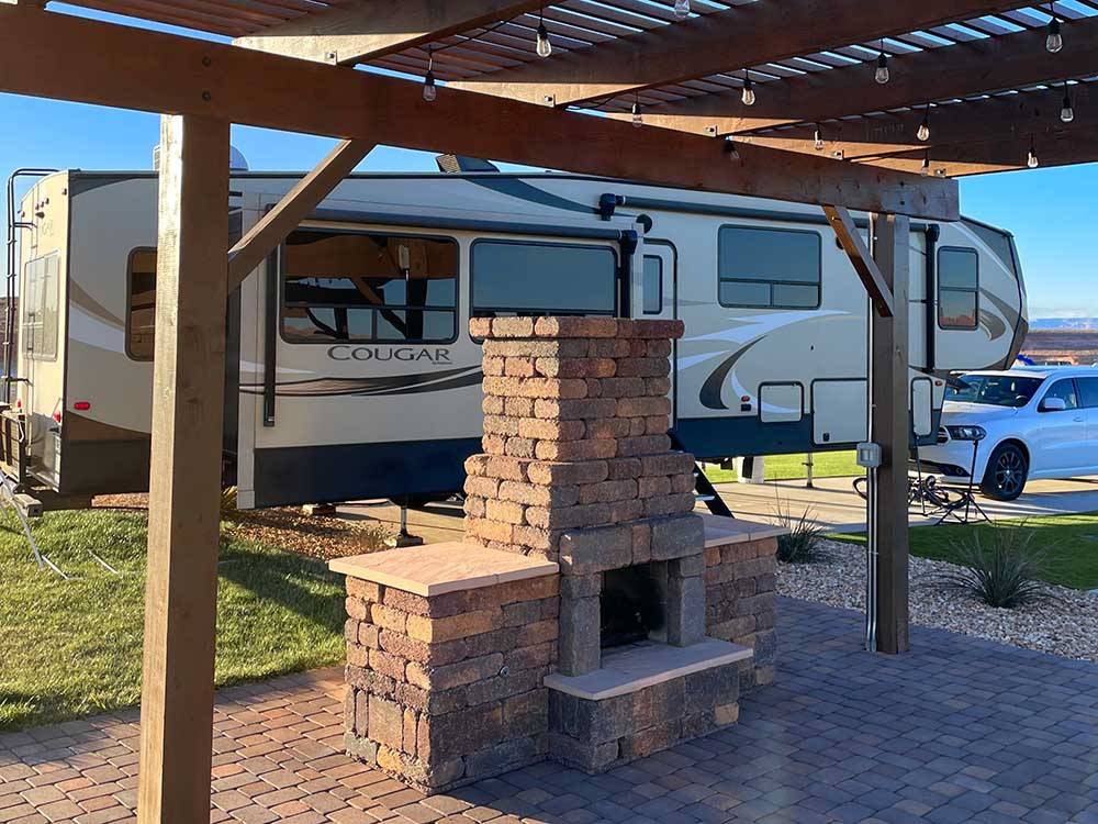A fifth wheel trailer parked next to a pergolas and fireplace at ANTELOPE POINT MARINA RV PARK