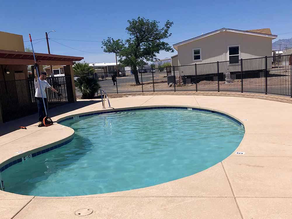 A man cleaning the swimming pool at PALO VERDE ESTATES