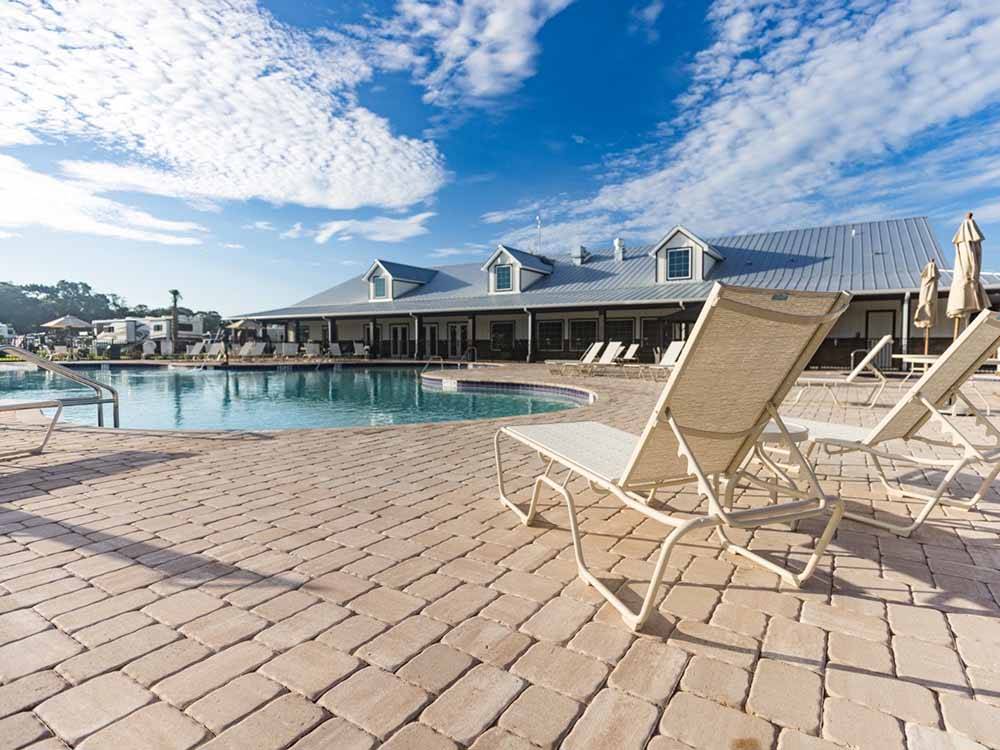 Pool side view with lounge chairs at CHAMPIONS RUN LUXURY RV RESORT