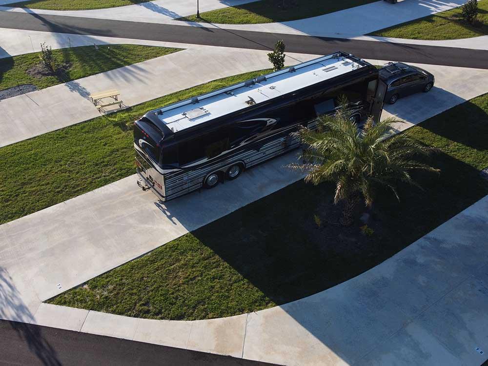 Aerial view of a Class A motorhome in a paved site at ORANGE LAKE RV RESORT