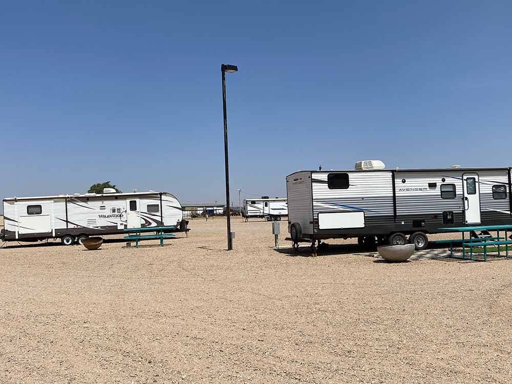 Travel trailers in gravel RV sites at CLOVIS POINT RV STABLES & STORAGE