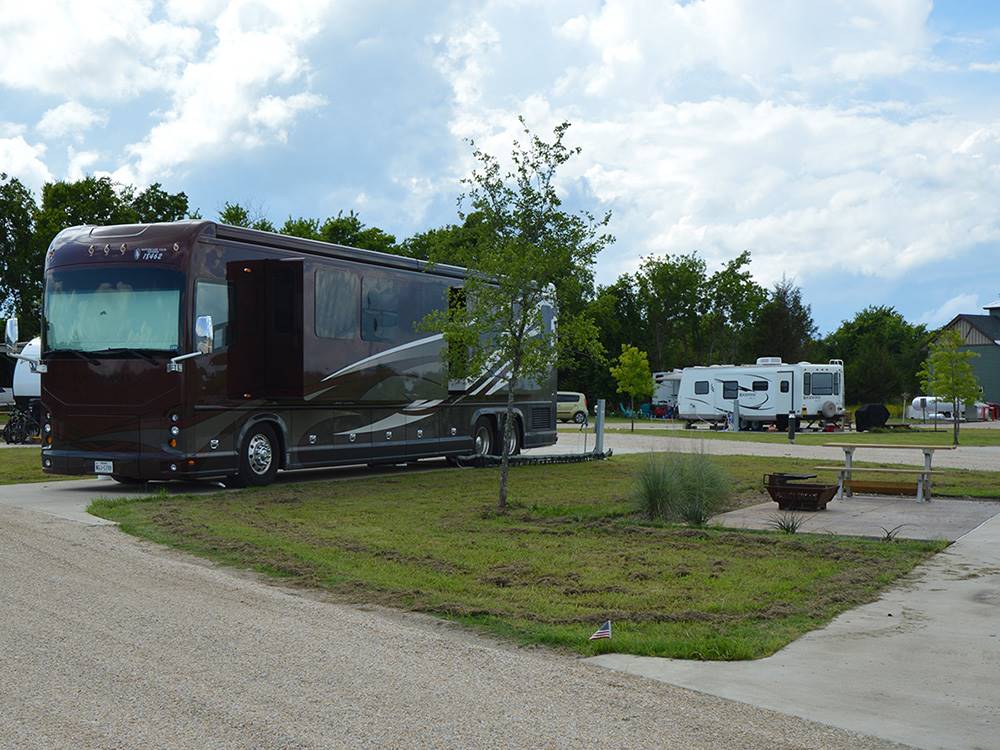 RVs parked in camping spaces at HIDDEN GROVE RV RESORT