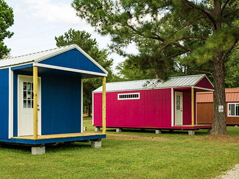 Two rental cabins by a tree at TALLADEGA PIT STOP RV PARK & CAMPGROUND