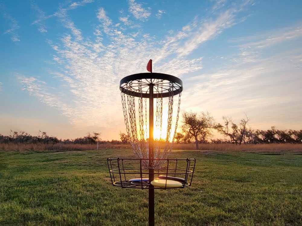 The disc golf course with the sun in the background at QUILLY'S BIG FISH RV PARK