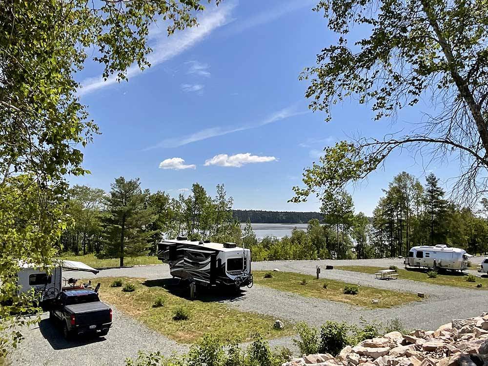 Parked RVs in gravel sites at WEST BAY ACADIA RV CAMPGROUND