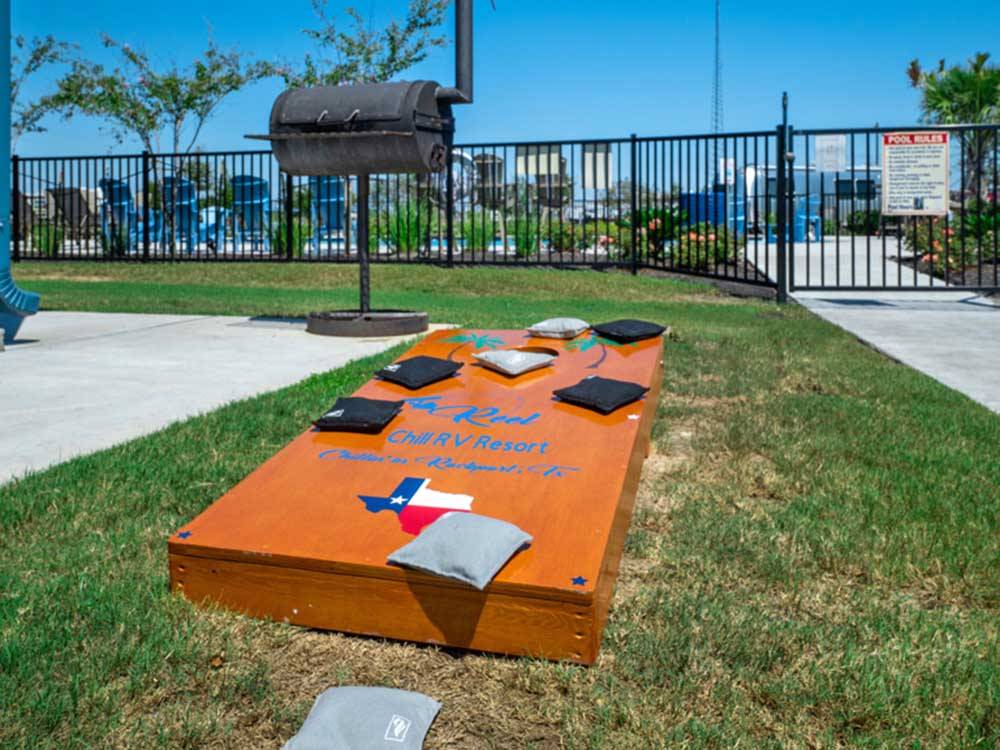 An outdoor area set up for a game of corn hole at REEL CHILL RV RESORT