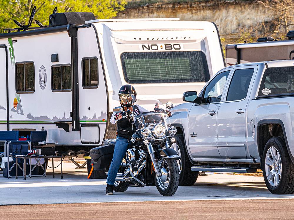 A person on a motorcycle leaving their site at Riverwalk RV Resort