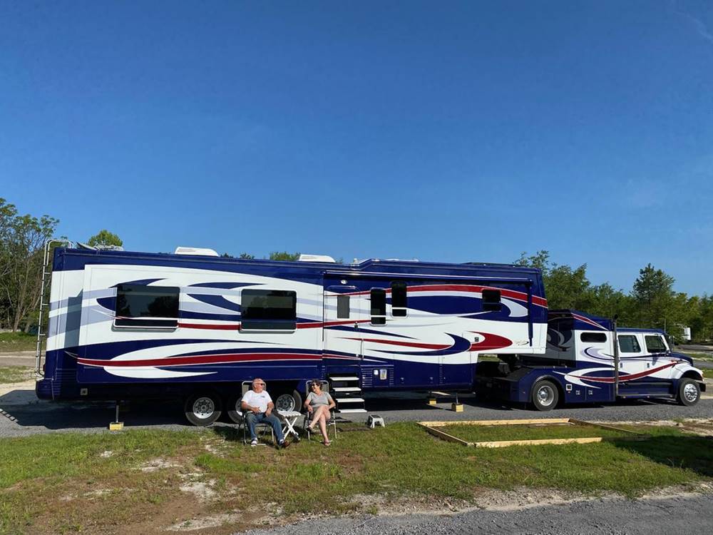 A couple sitting in front of their RV at BIG RIG FRIENDLY RV RESORT