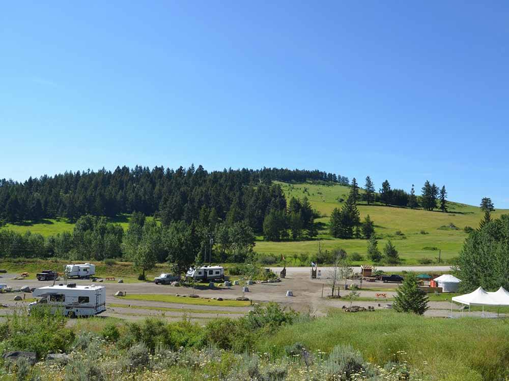 Green hills with trees and RVs at SUMMIT RV RESORT