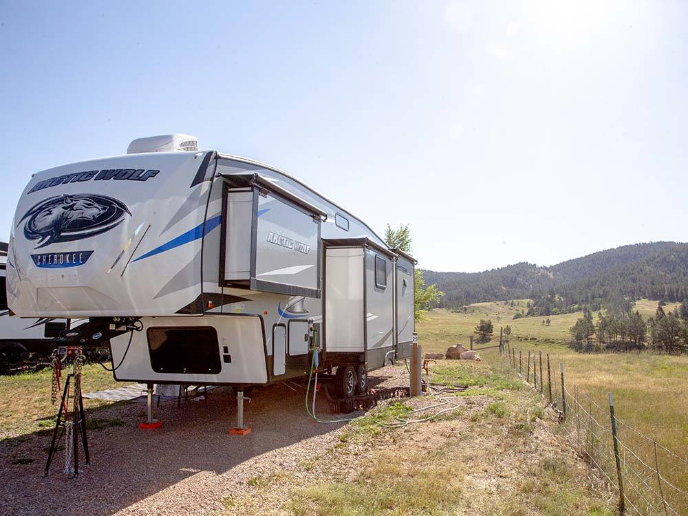 A Cherokee travel trailer in a gravel site at SUNRISE RIDGE CAMPGROUND