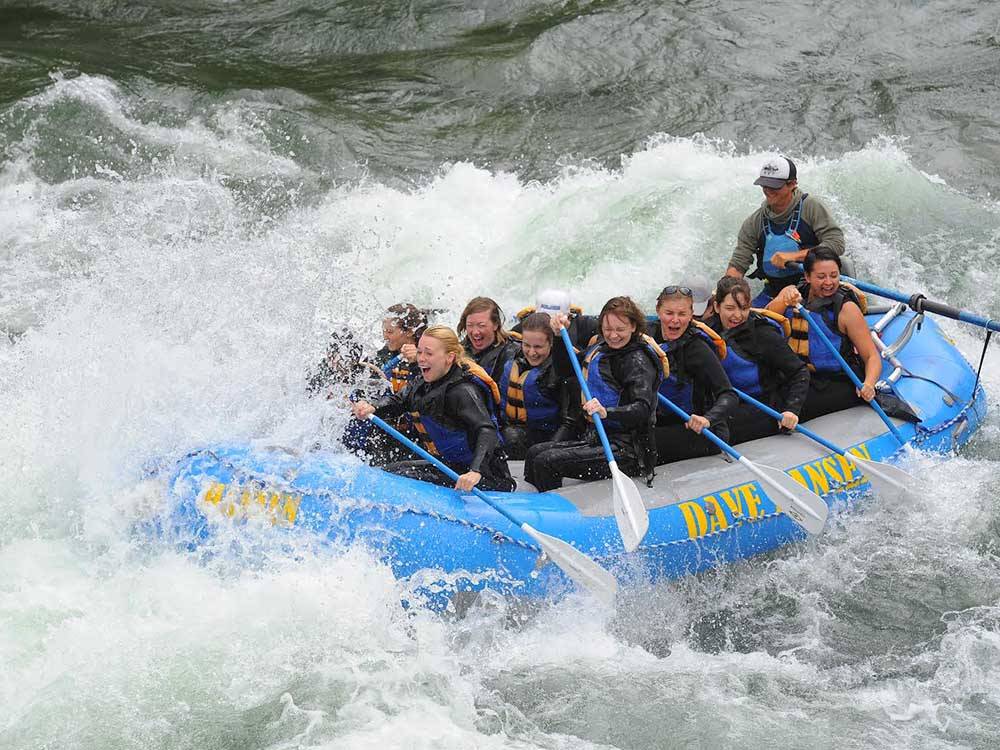 A group riding a large raft on the rapids near ALPINE VALLEY RV RESORT