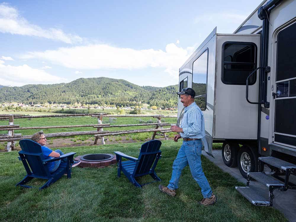 A couple relaxing outside their RV at ALPINE VALLEY RV RESORT