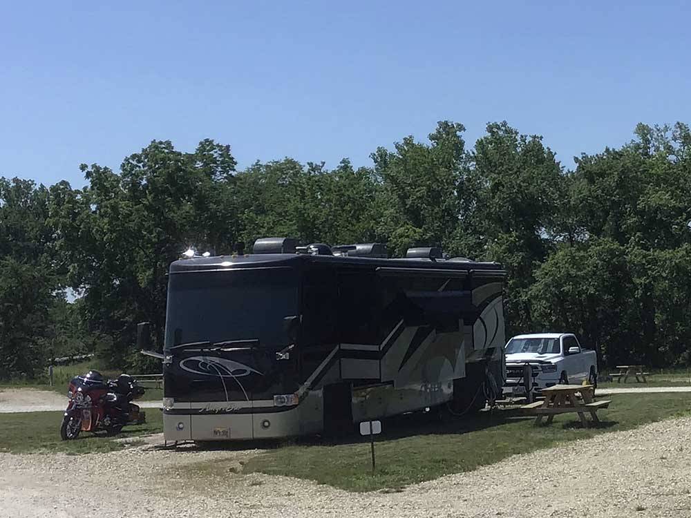 Allegro Bay motorhome in campsite with motorcycle at CROWS NEST RV RESORT