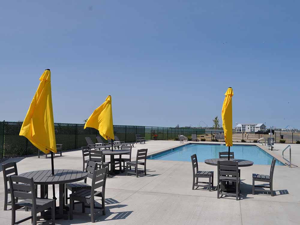 Tables and chairs with yellow umbrellas next to the swimming pool at BAYFRONT RESORT AT CROSS VIEW
