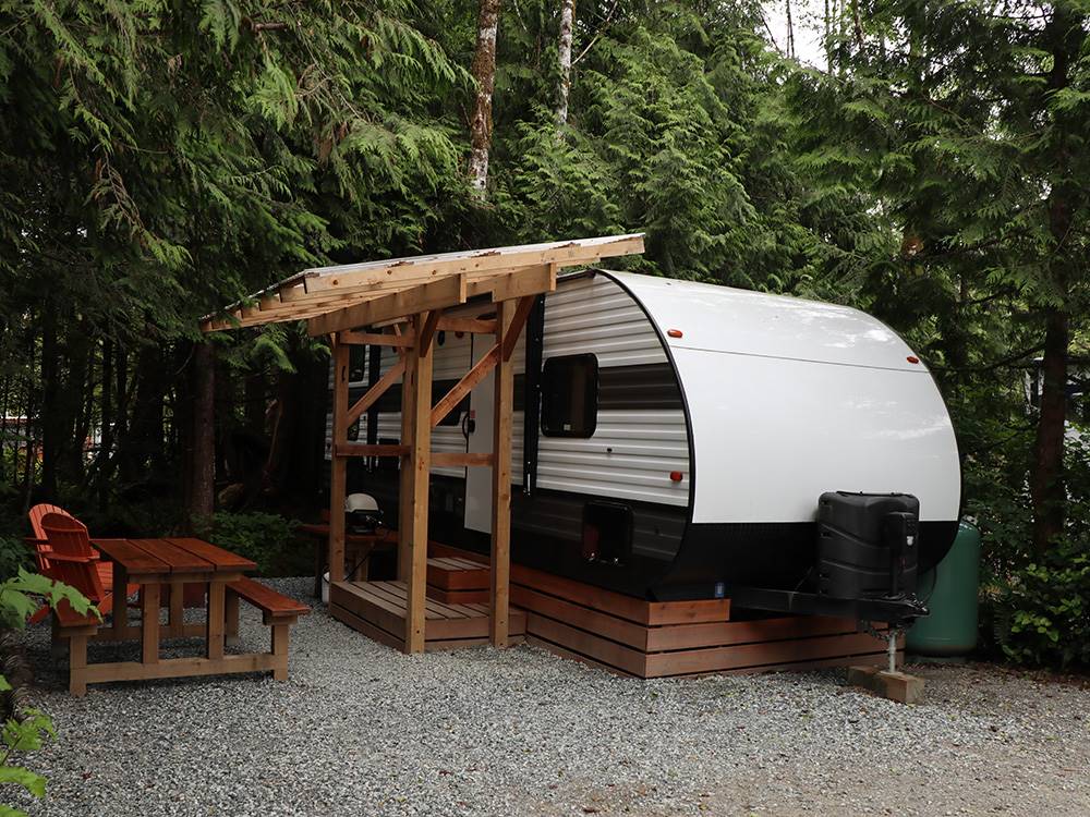 A travel trailer with a table and chairs at SURF GROVE CAMPGROUND