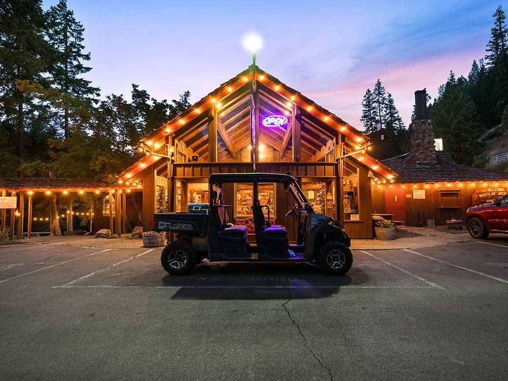 A golf cart in front of the main building at WHISTLIN JACKS OUTPOST LODGE