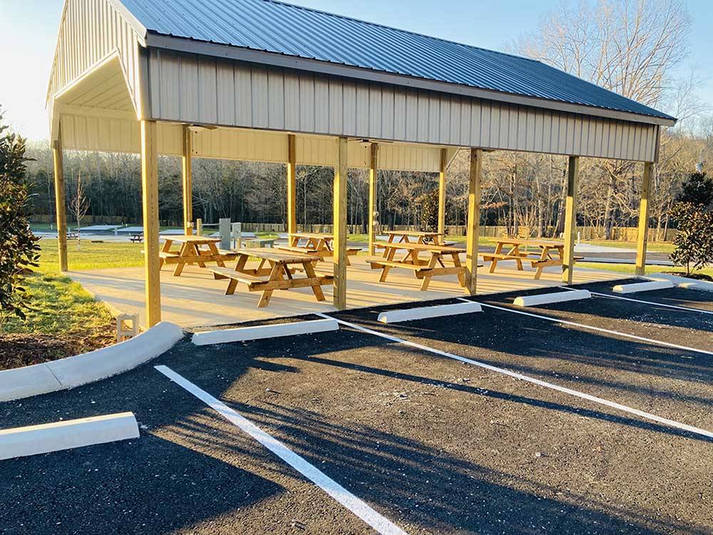 Picnic tables under a pavilion at WHISPERING FALLS RV PARK AND STORE