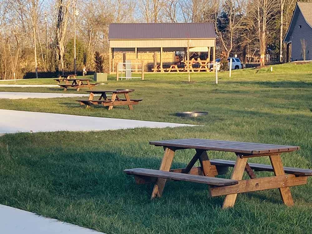 Picnic tables next to paved RV sites at WHISPERING FALLS RV PARK AND STORE