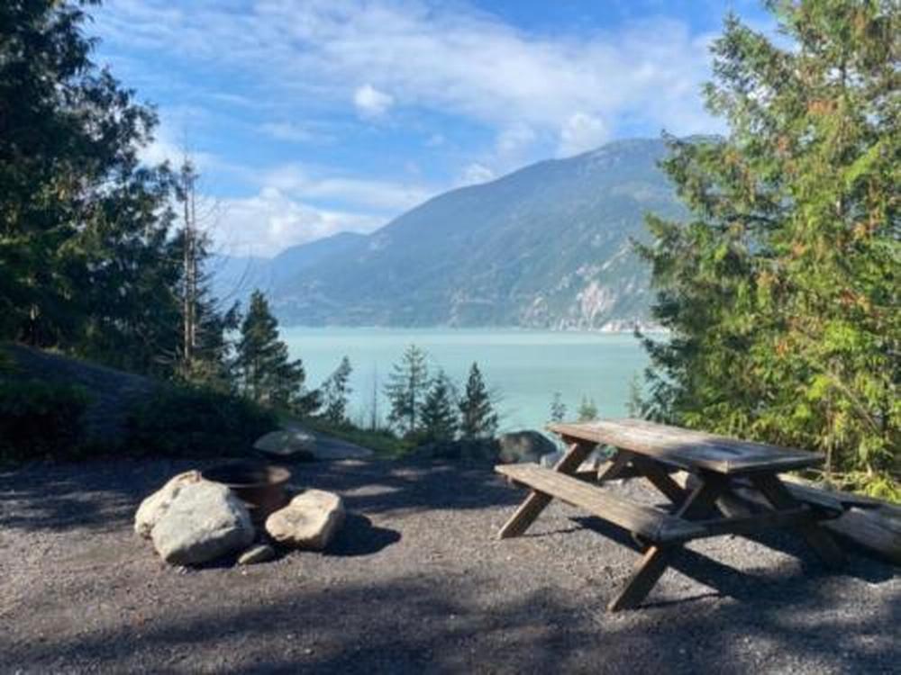 A sit with a fire pit and view of the water at Klahanie Campground