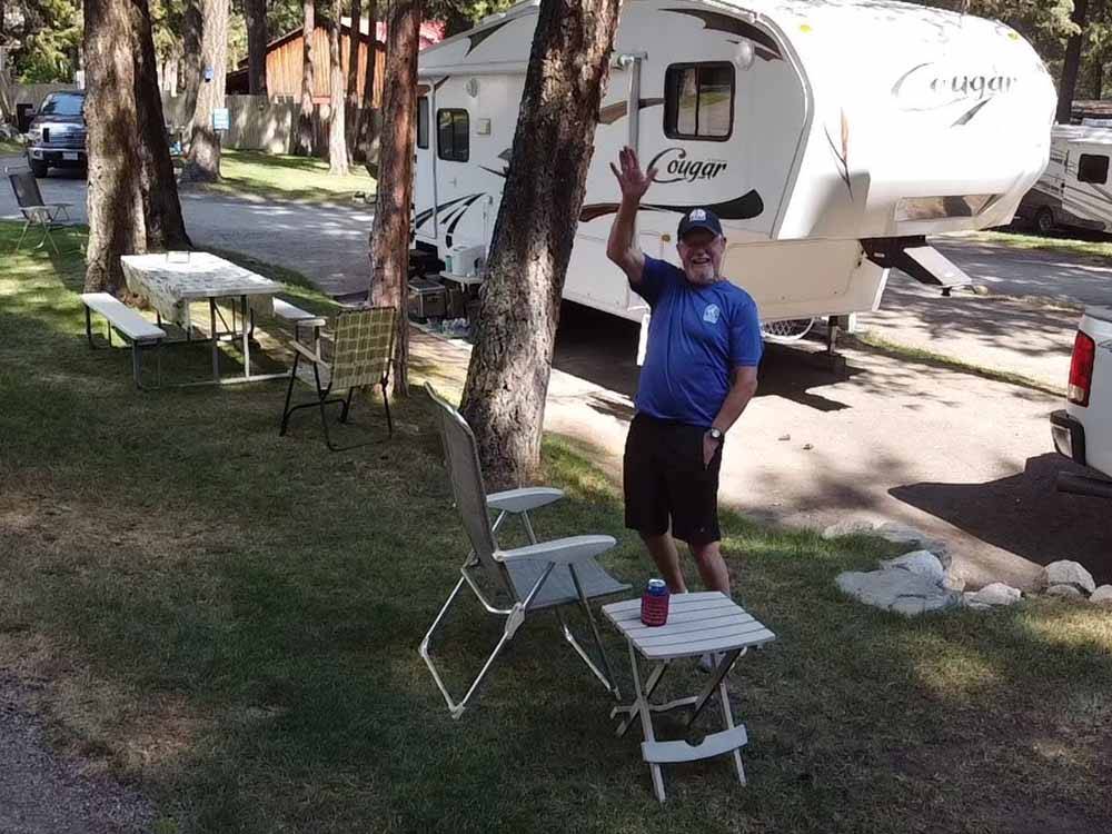 A man waving from his campsite at RIVERHAVEN RV PARK & MOTEL