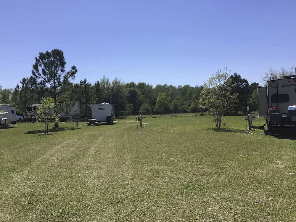 A grassy field with RVs at DREAMLAND RV PARKS