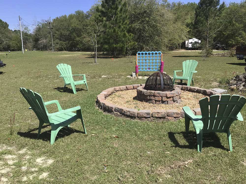 A group of chairs around a fire pit at DREAMLAND RV PARKS