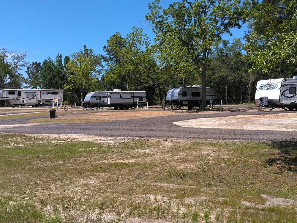 A row of trailers in paved sites at PEBBLE HILL RV RESORT