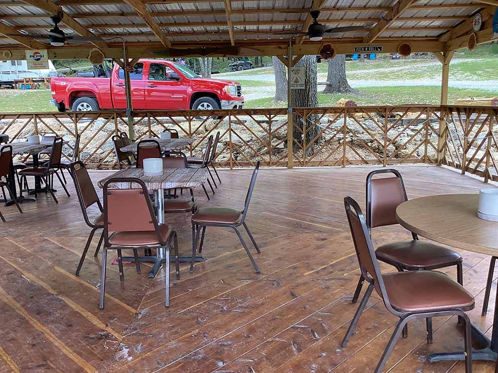 Chairs and tables under the pavilion at KELLER'S KOVE CABIN AND RV RESORT