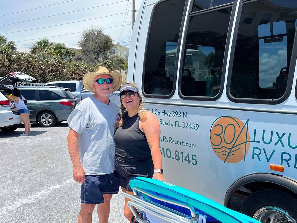 A couple standing next to the shuttle bus at 30A LUXURY RV RESORT