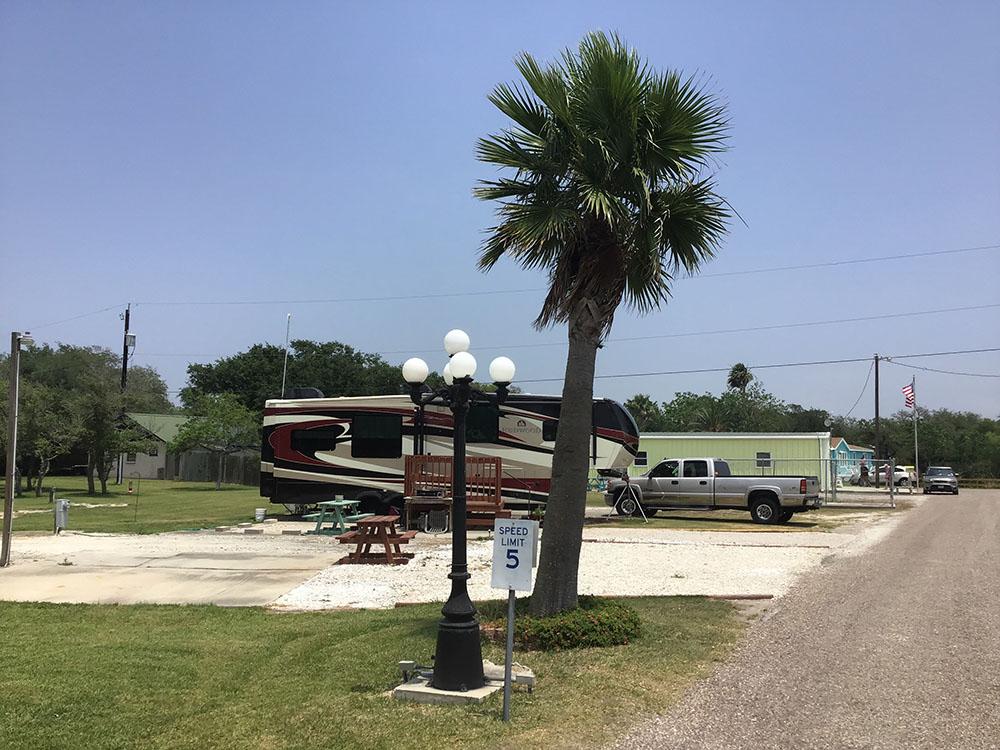 A fifth wheel trailer in a gravel RV site at ROCKPORT RV RANCH
