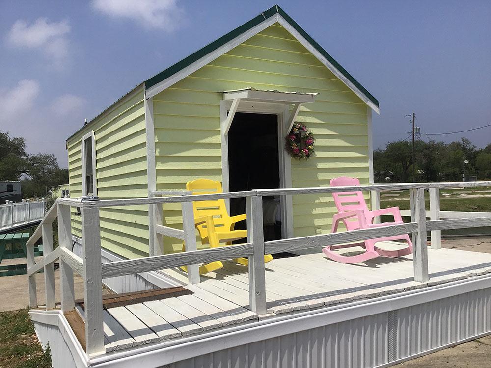 A colorful rental cabin with chairs in the front at ROCKPORT RV RANCH