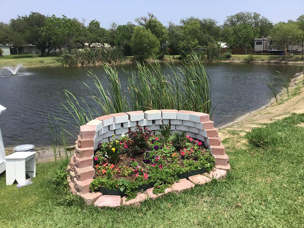 A flower bed next to the lake at ROCKPORT RV RANCH