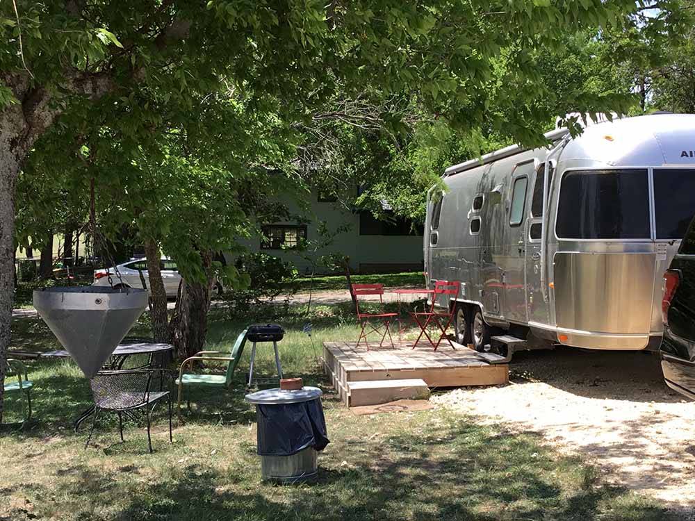 Shaded campsite with deck and Airstream at OFF THE VINE RV PARK
