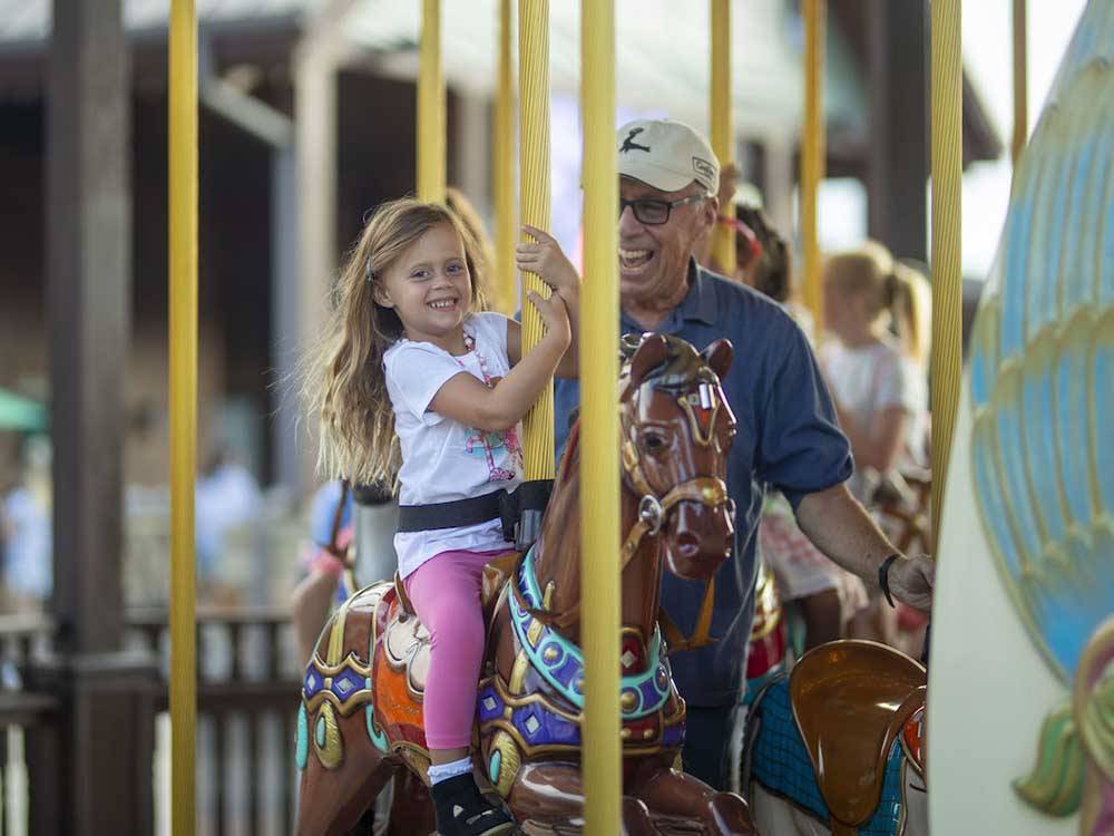 A little girl enjoying the carousel at TRYON INTERNATIONAL RV RESORT